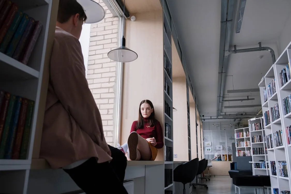 Free Two Teenagers Sitting by the Window of the Library Stock Photo