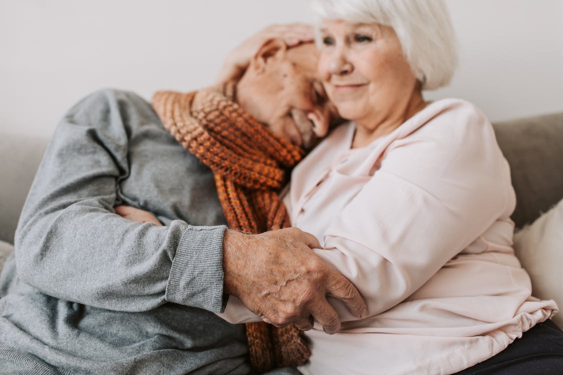 Free Woman in White Dress Shirt Hugging Man in Gray Sweater Stock Photo
