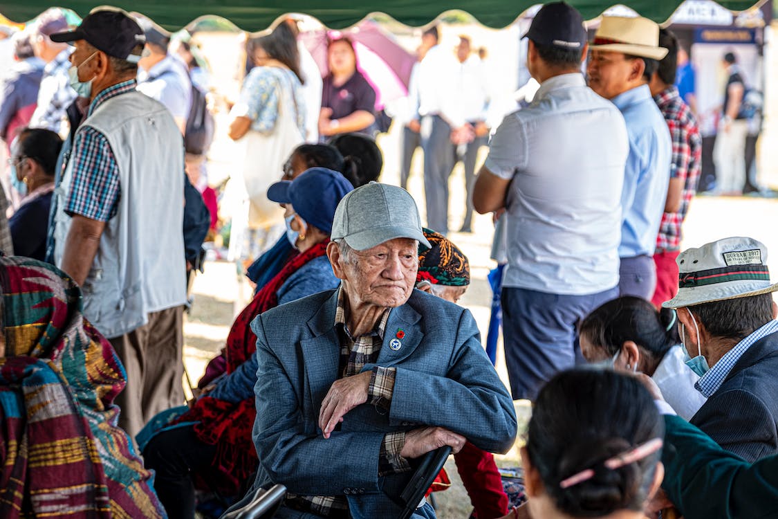 Free An Elderly Man Sitting Among Crowd of People Stock Photo