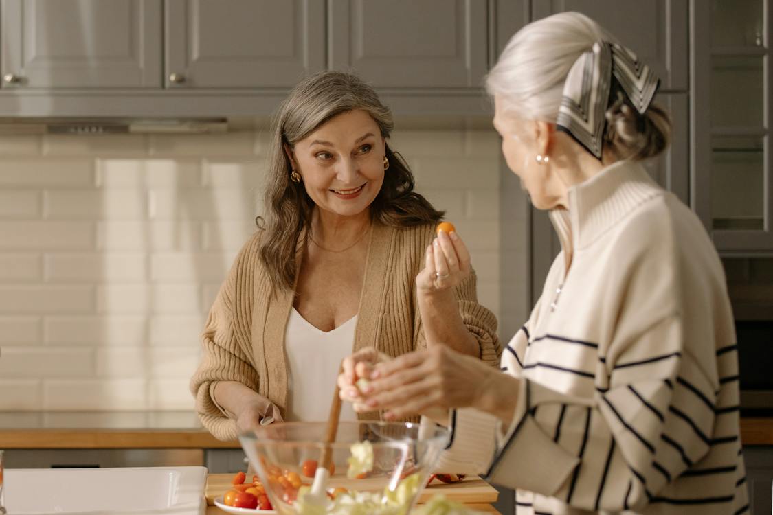 Free An Elderly Woman in Knitted Cardigan Holding a Cherry Tomato Stock Photo