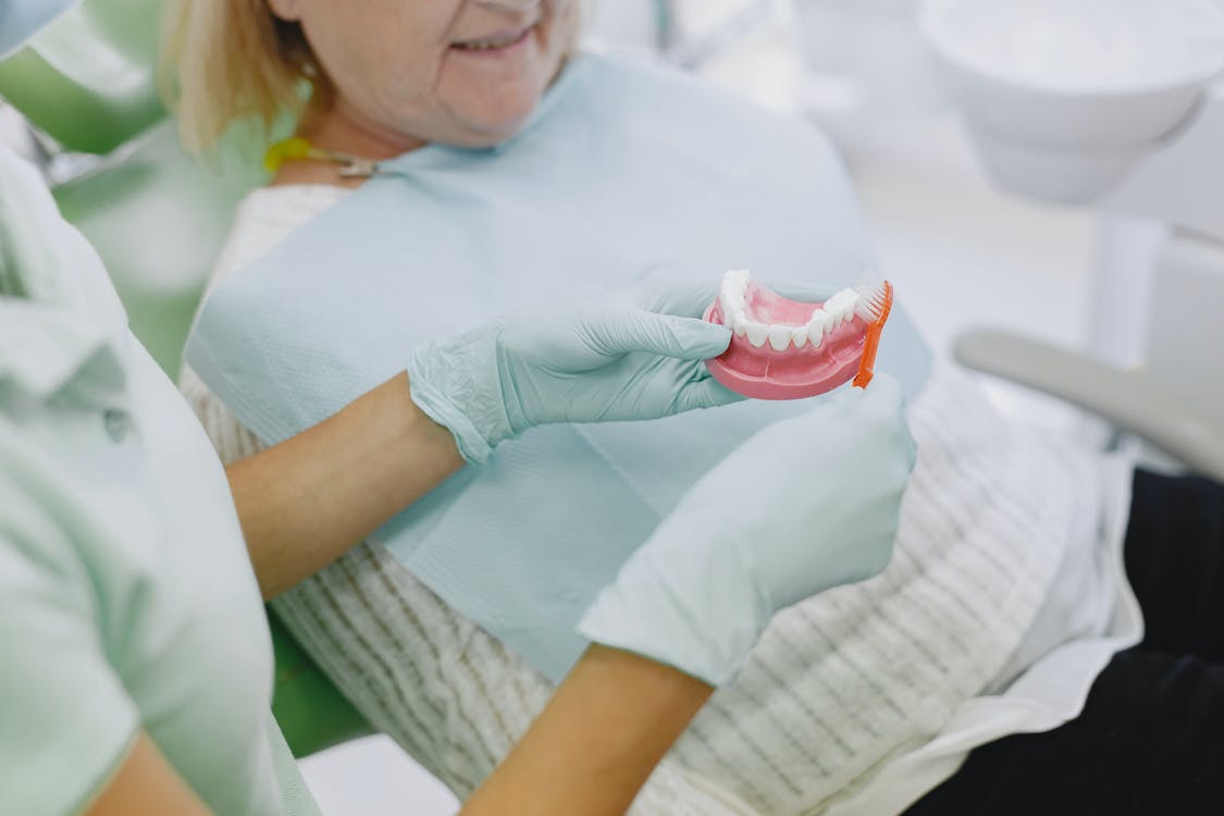 Free A Dentist Showing a Denture to a Patient Stock Photo